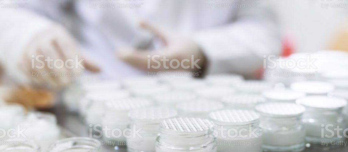 Close up picture of packing a face cream in bottles.